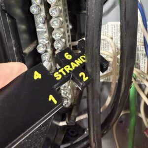 Stranded wire gauge tool in use at an electrical panel